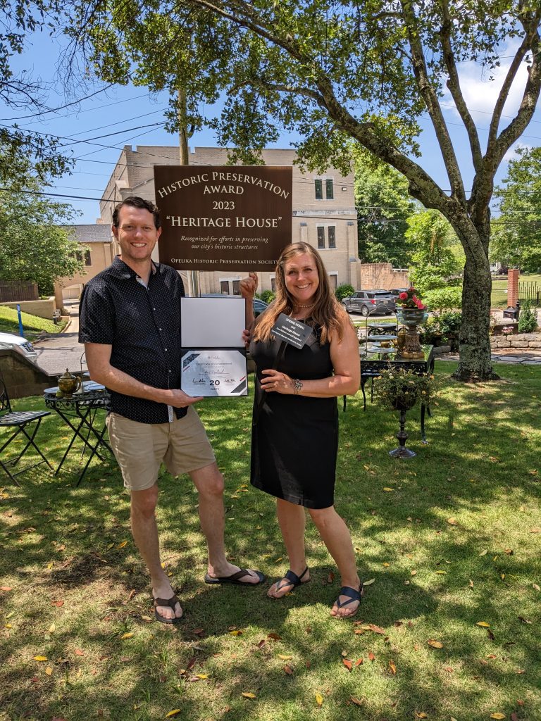 Innkeepers Leif & Dani showing off awards given by the Opelika Historic Preservation Society as well as their Opelika Chamber of Commerce Small Business of the Year